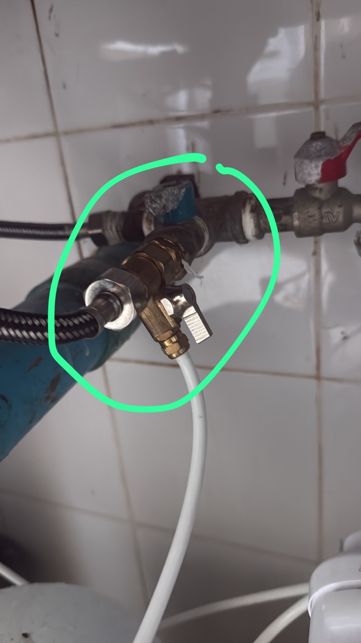 Brass tee and valve on the water pipe, circled in green